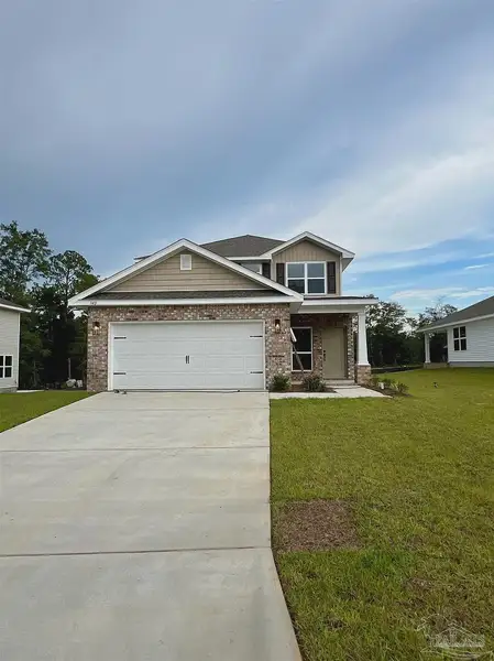 Front exterior of a new home in Pine Top, Cantonment, FL, highlighting curb appeal (Image 1).