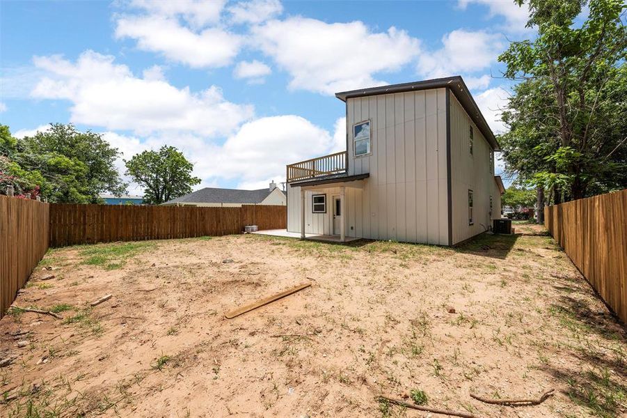 Back of property featuring a balcony, a fenced backyard, a patio, and board and batten siding Back of property featuring a balcony, a fenced backyard, a patio, and board and batten siding