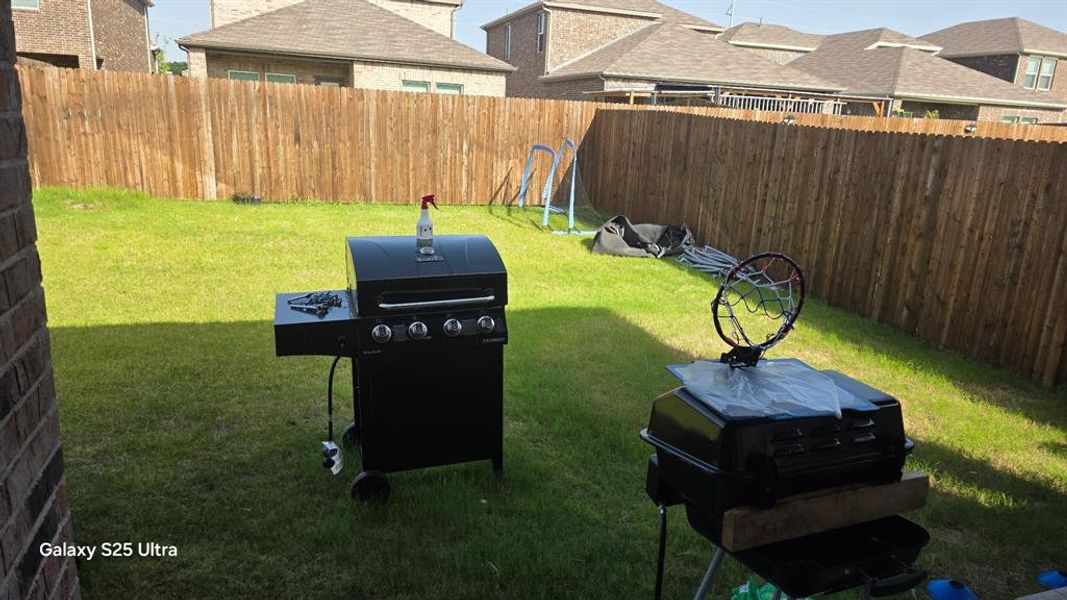 Expansive rear yard featuring green lawn and a full privacy fence Expansive rear yard featuring green lawn and a full privacy fence