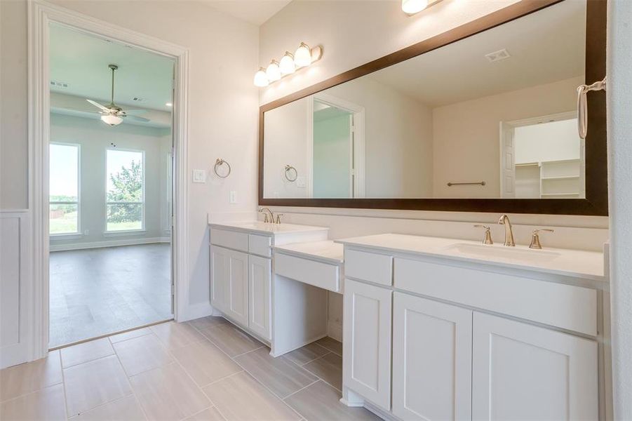 Bathroom with ceiling fan, double vanity, and tile patterned flooring