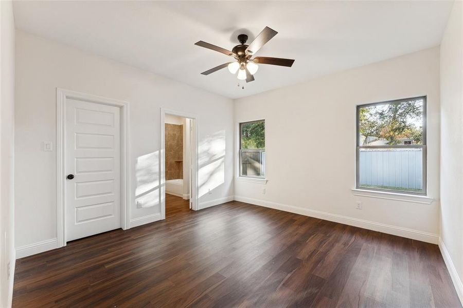 Empty room featuring dark wood-style floors and a ceiling fan