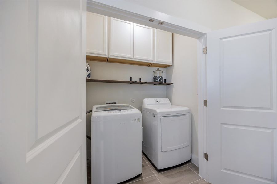 Laundry area with washer and dryer, light tile patterned floors, and cabinet space Laundry area with washer and dryer, light tile patterned floors, and cabinet space