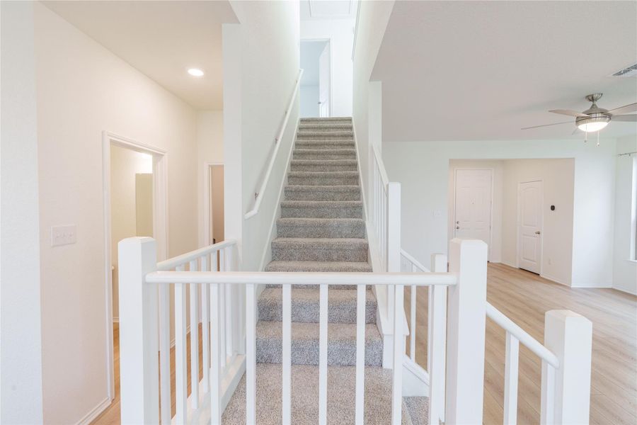 A grand central staircase provides a focal point, separating an inviting entryway from open living areas. A grand central staircase provides a focal point, separating an inviting entryway from open living areas.