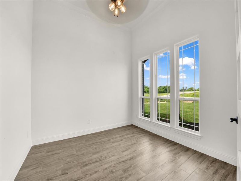 Empty room featuring ceiling fan, wood finished floors, baseboards, and crown molding Empty room featuring ceiling fan, wood finished floors, baseboards, and crown molding