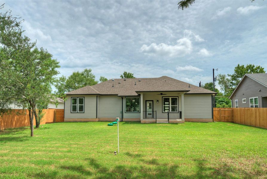 Rear view of property with a ceiling fan, a fenced backyard, and roof with shingles Rear view of property with a ceiling fan, a fenced backyard, and roof with shingles