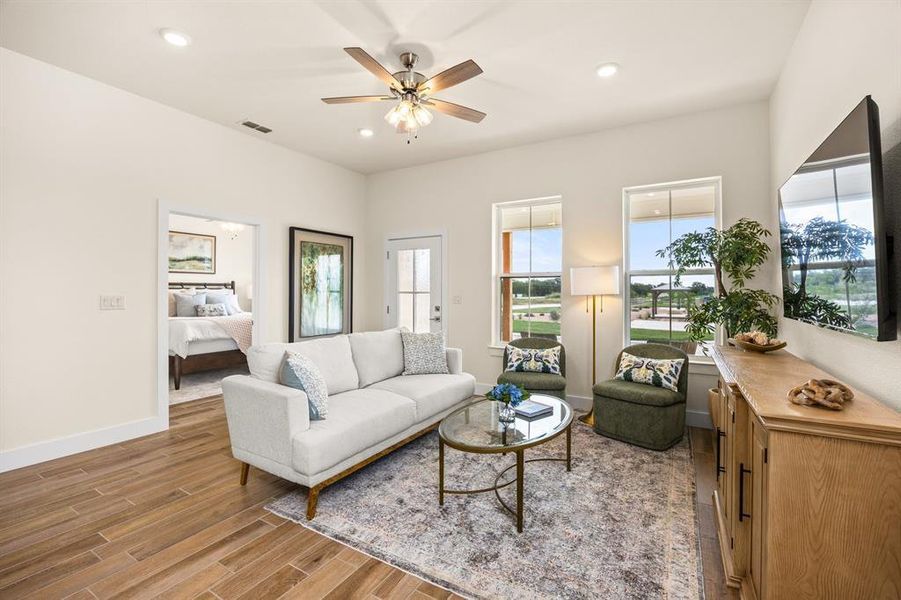 Spacious living area featuring wood-finish flooring, recessed lighting, and a ceiling fan