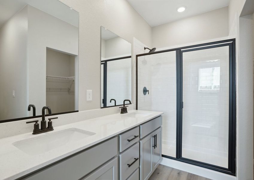 The master bathroom has a dual sink vanity and a step in shower.