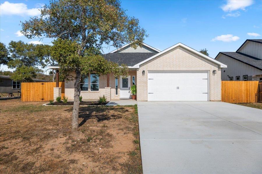 Single story home featuring concrete driveway, brick siding, and a garage