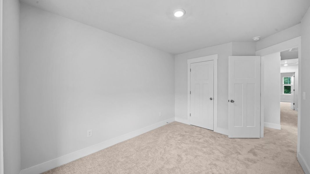 Bedroom featuring soft carpeting and a thoughtfully designed walk-in closet at Saluda Crossing by DRB Homes in Piedmont, SC