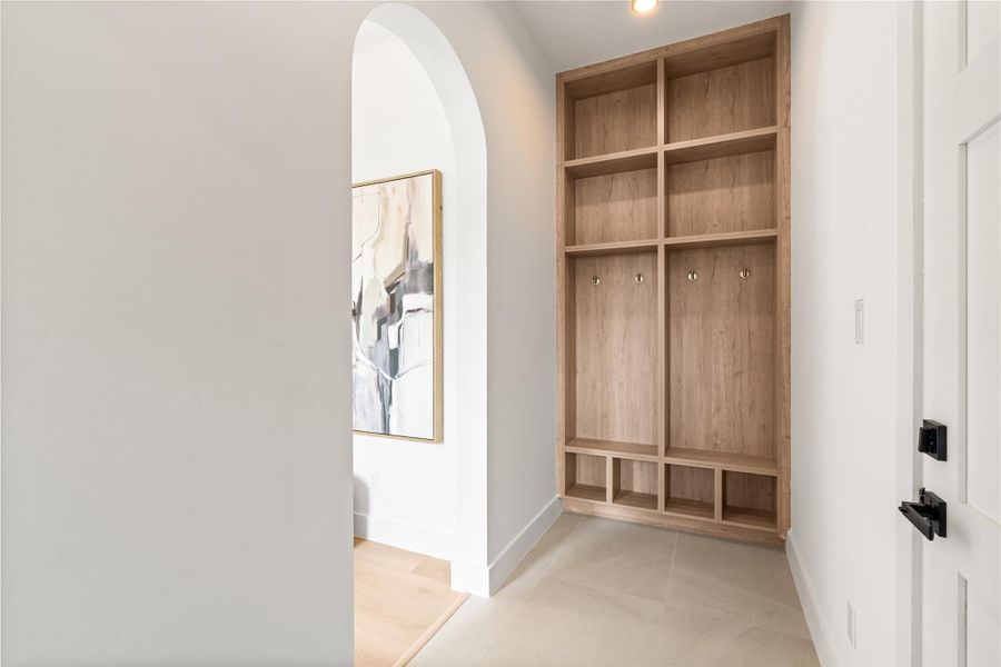 Built-in wood cubbies and hooks give this drop zone real function, keeping shoes, bags, and daily clutter contained right at the entry. It's a small space that solves a big everyday problem.