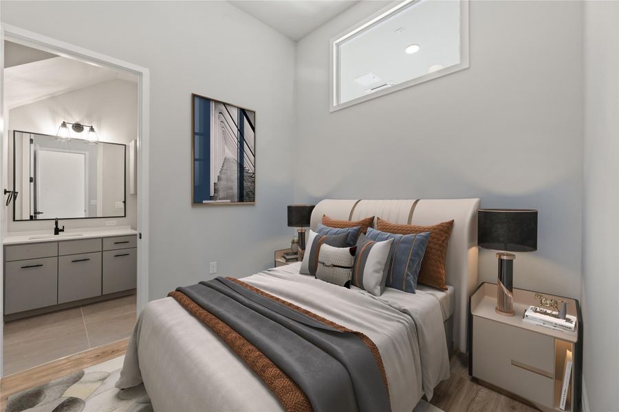 Bedroom featuring a sink, light wood finished floors, and ensuite bathroom
