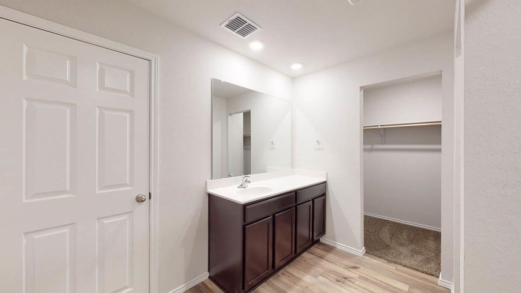 Vanity area featuring a dark wood-finish cabinet with a white countertop and a rectangular mirror
