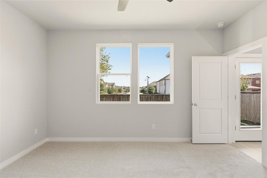 Spare room featuring light colored carpet and ceiling fan