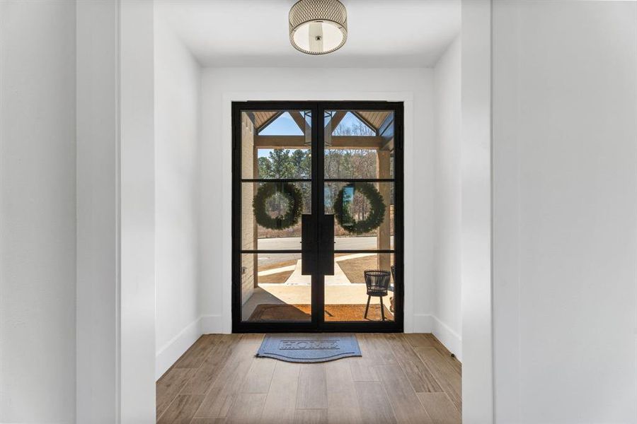 Entryway featuring wood finished floors, baseboards, and french doors Entryway featuring wood finished floors, baseboards, and french doors