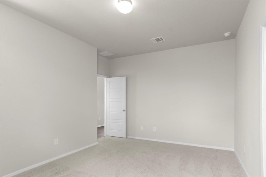 Spare room with light colored carpet and baseboards
