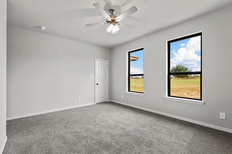 Carpeted empty room with ceiling fan