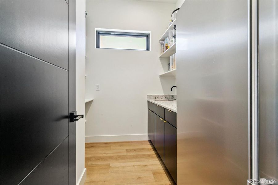 Butler pantry with freezer and ice maker; utility sink