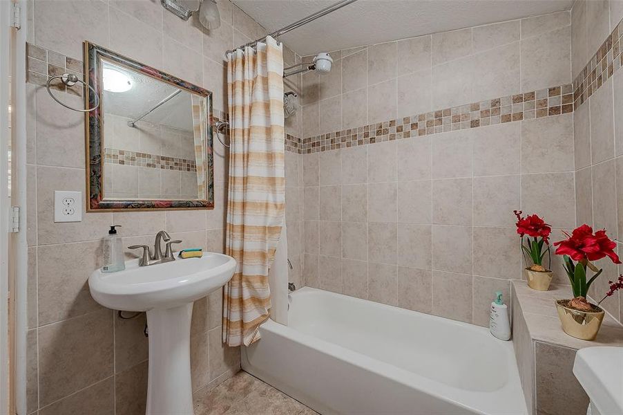 Enjoy a moment of relaxation in this spacious bathroom with a shower/tub combo.