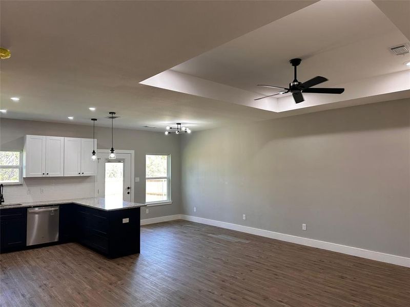 Highlighting the detailed ceiling and lighting and remote controled ceiling fan in living room.