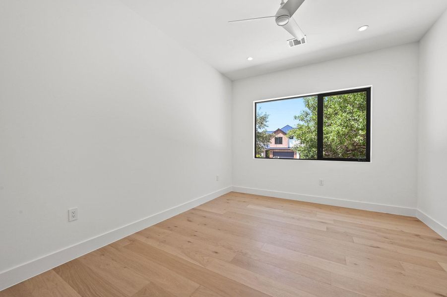 Empty room featuring light wood-style floors, recessed lighting, and a ceiling fan