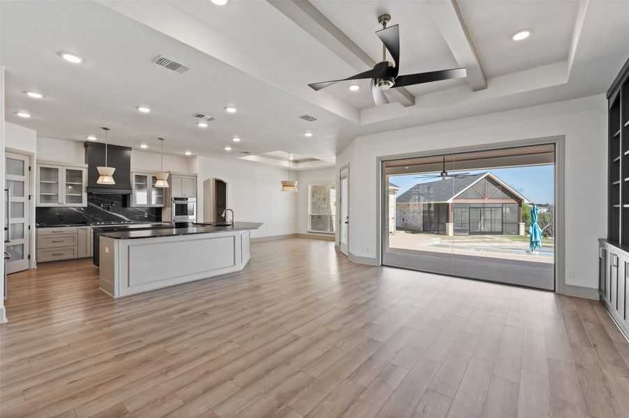 Kitchen featuring visible vents, light wood-style flooring, a sink, dark countertops, and ceiling fan