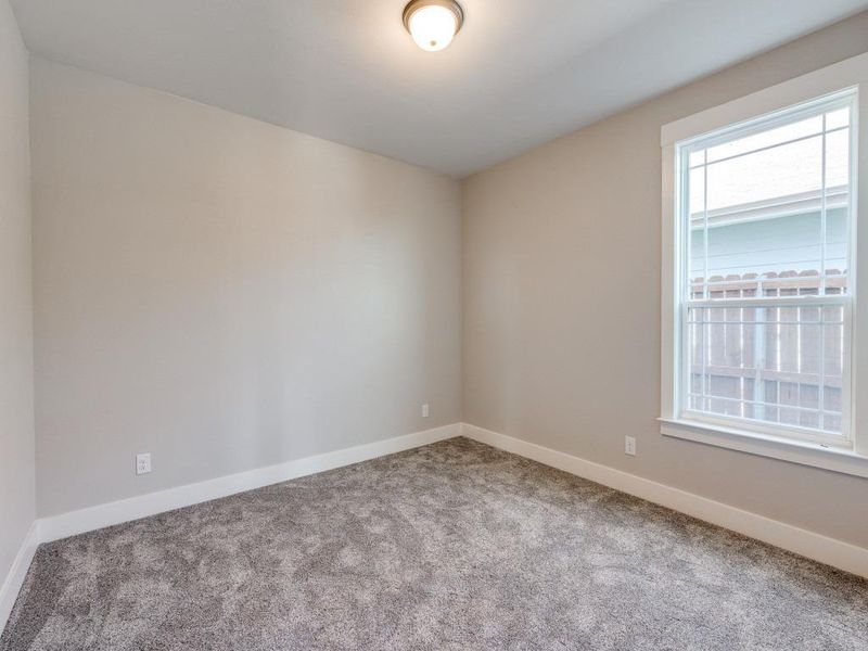 Carpeted spare room featuring baseboards