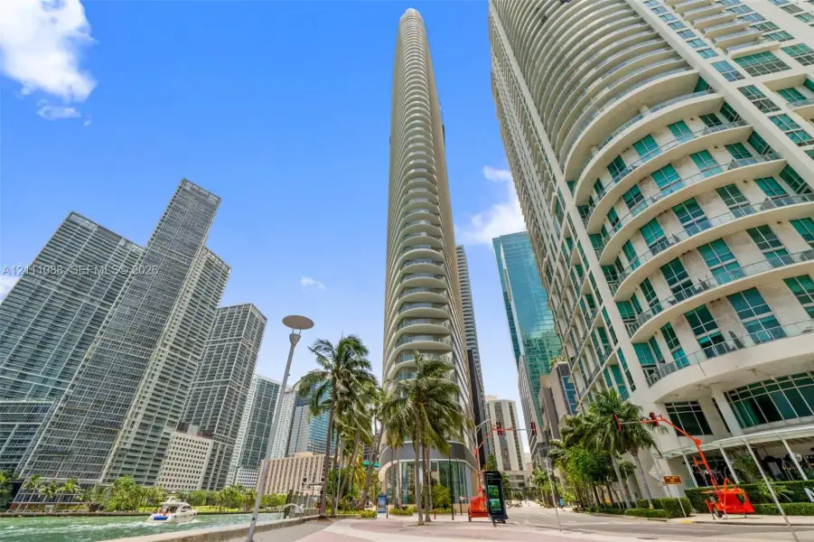High-rise glass facade, curved balcony detailing, and structural concrete exterior elements High-rise glass facade, curved balcony detailing, and structural concrete exterior elements