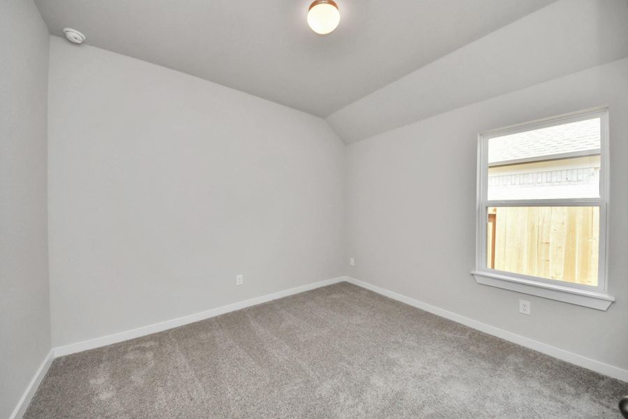 Secondary bedroom features plush carpeting, large windows that let in plenty of natural light, bright paint, and spacious closets. Sample photo of completed home with similar floor plan. Actual colors and selections may vary.