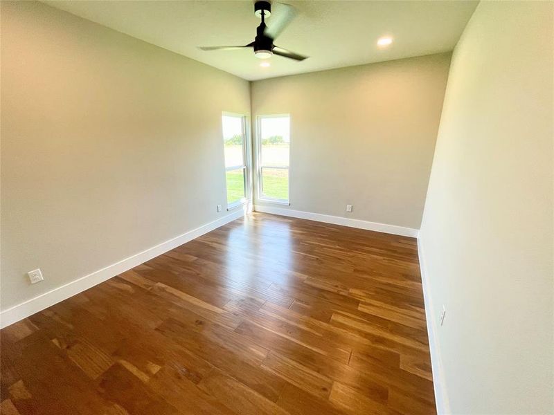 Empty room featuring ceiling fan and hardwood / wood-style floors