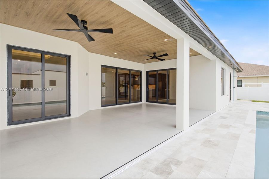 Expansive covered patio with wood-accent ceiling and dual fans offers a stylish space for year-round outdoor living. Expansive covered patio with wood-accent ceiling and dual fans offers a stylish space for year-round outdoor living.