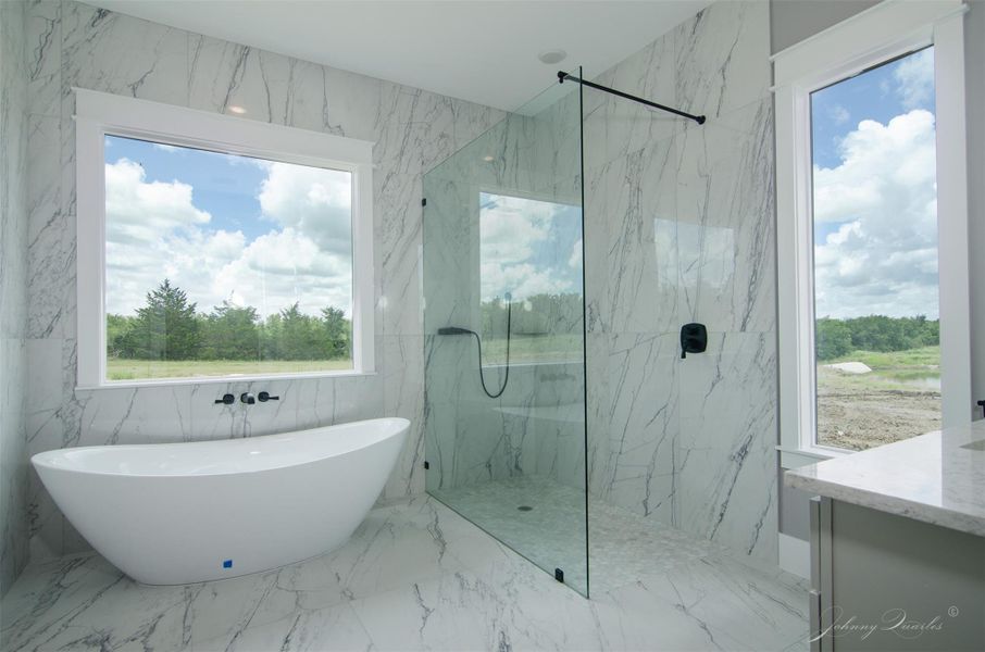 Luxurious Primary Ensuite with large format tile features tons of natural light, a 6 foot tub and large shower space. Luxurious Primary Ensuite with large format tile features tons of natural light, a 6 foot tub and large shower space.