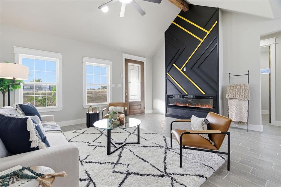 Living room featuring healthy amount of natural light, a glass covered fireplace, ceiling fan, and wood finish floors