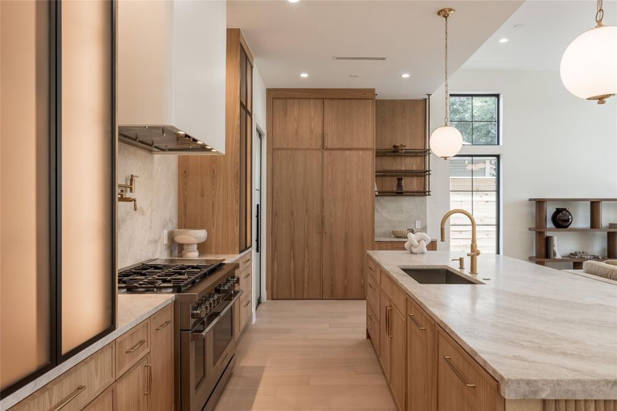 The chef’s kitchen pairs custom white oak cabinetry with natural stone surfaces and a Taj Mahal quartzite backsplash, while panel ready Fisher & Paykel refrigerator and freezer columns disappear seamlessly into the cabinetry. A 48 inch Fisher & Paykel dual fuel range completes the professional appliance package. The chef’s kitchen pairs custom white oak cabinetry with natural stone surfaces and a Taj Mahal quartzite backsplash, while panel ready Fisher & Paykel refrigerator and freezer columns disappear seamlessly into the cabinetry. A 48 inch Fisher & Paykel dual fuel range completes the professional appliance package.