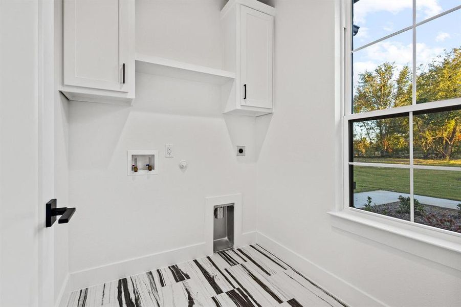 Washroom featuring gas dryer hookup, electric dryer hookup, washer hookup, and cabinet space