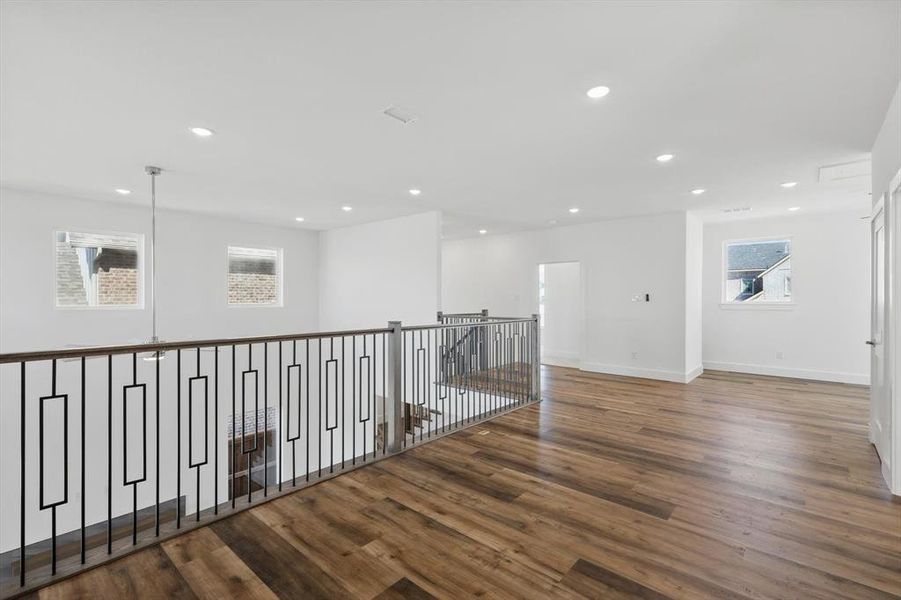 Corridor featuring baseboards, wood finished floors, and recessed lighting