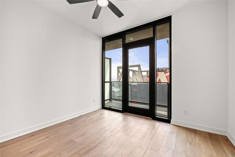 Representative Photo. Open Concept living room with 7.5" wide Bella Cera hardwood flooring throughout, balcony off the living room with a South view