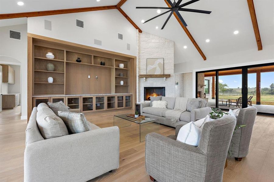 Living room featuring high vaulted ceiling, light
wood-type flooring, beamed ceiling, a stone
fireplace, and recessed lightingwood-type flooring, beamed ceiling, a stone
fireplace, and recessed lighting Living room featuring high vaulted ceiling, light
wood-type flooring, beamed ceiling, a stone
fireplace, and recessed lightingwood-type flooring, beamed ceiling, a stone
fireplace, and recessed lighting