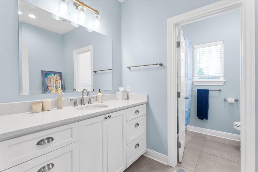 Hallway Full Bathroom featuring vanity, a shower with tub and light tile patterned floors