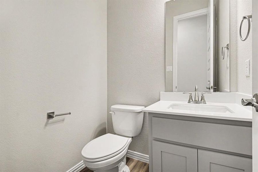 Bathroom vanity with a white countertop and integrated sink, brushed nickel faucet, and a large wall mirror Bathroom vanity with a white countertop and integrated sink, brushed nickel faucet, and a large wall mirror