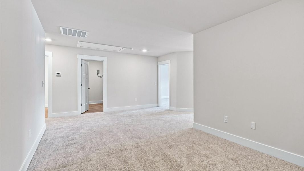 Vibrant carpeted loft offering flexibility as a study nook, game room, or second family space at Village at Midway
