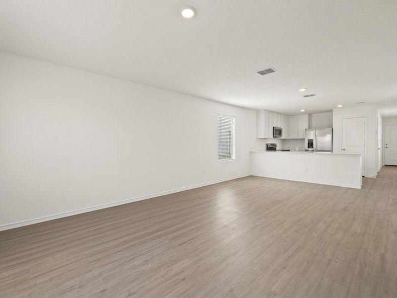 Photo has been enhanced with virtual modifications.  Unfurnished living room featuring light wood-style flooring and recessed lighting