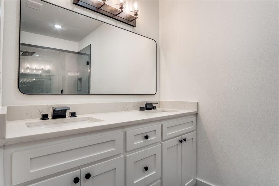 Full bathroom featuring a shower stall and double vanity