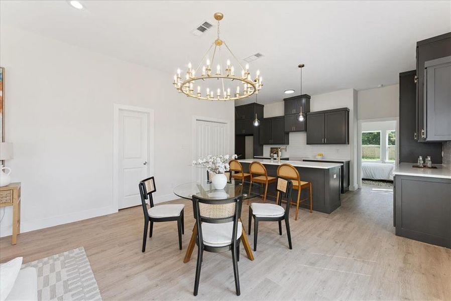 Dining area featuring light wood-type flooring, a chandelier, and recessed lighting