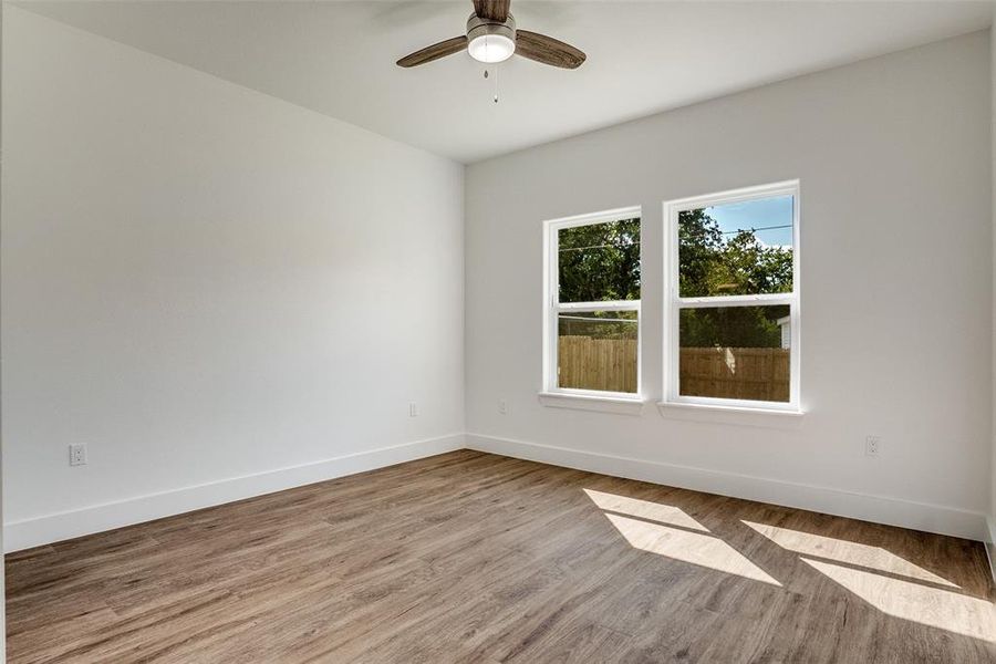 Empty room with light wood-style floors and a ceiling fan Empty room with light wood-style floors and a ceiling fan