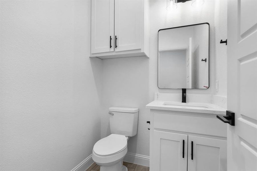 Bathroom featuring vanity, wood-type flooring, and toilet