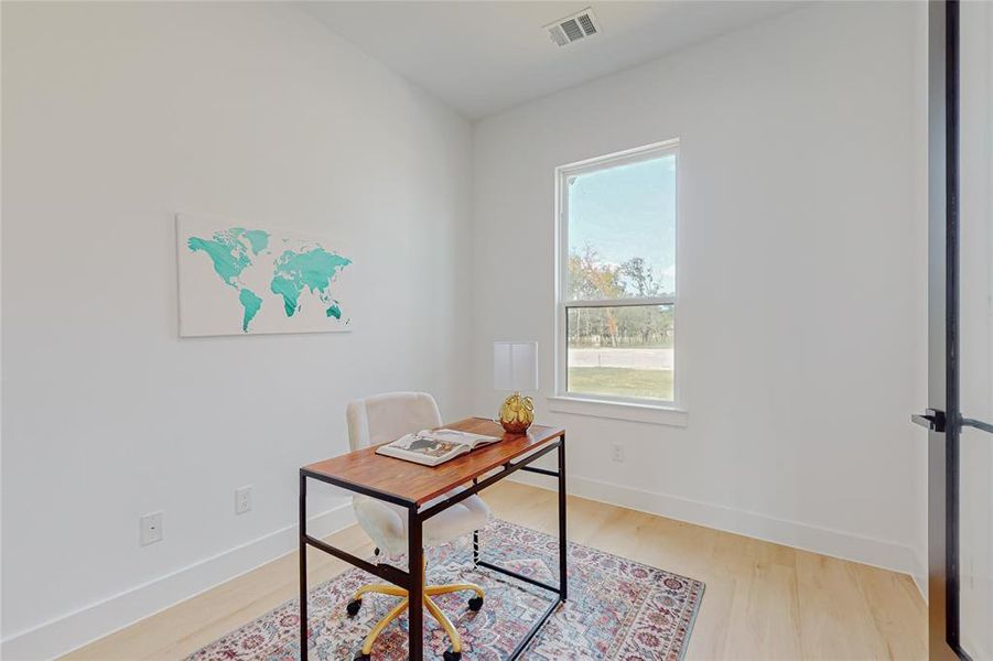 Office space with plenty of natural light and light hardwood / wood-style floors