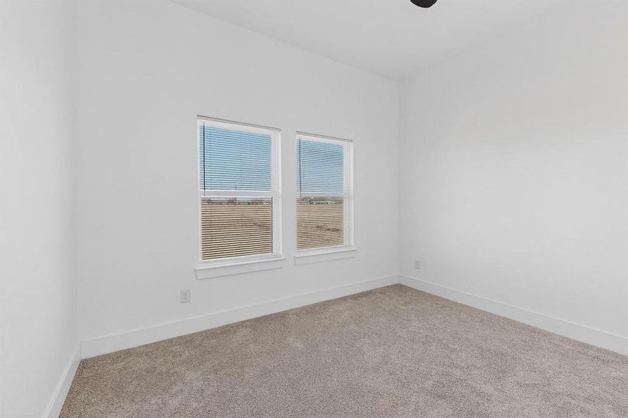 Empty room featuring light colored carpet and baseboards