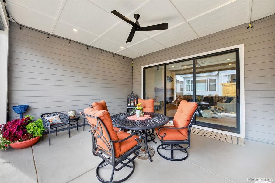 Covered Patio (View 2) – Seamless indoor-outdoor connection through sliding glass doors to the covered patio, featuring comfortable seating and low-maintenance concrete flooring.
