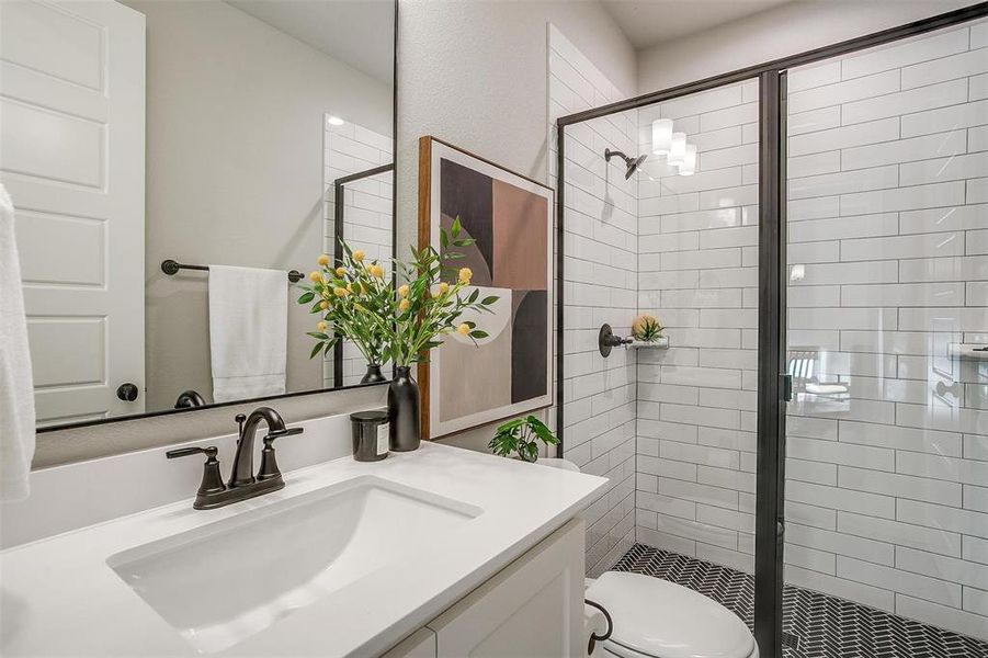 Full bath featuring a shower stall, toilet, and vanity Full bath featuring a shower stall, toilet, and vanity