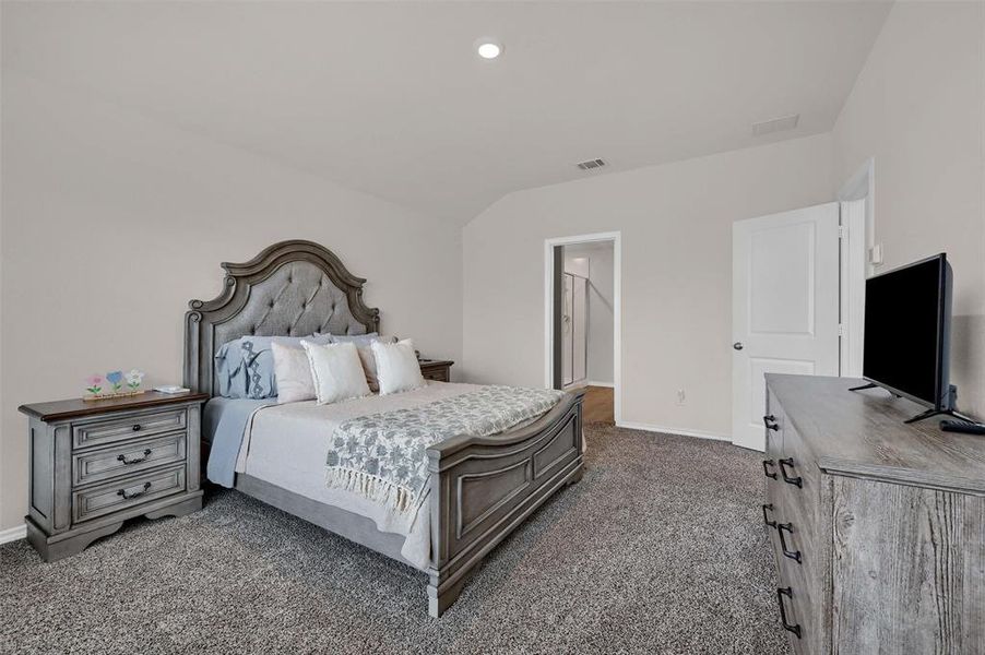 Bedroom featuring vaulted ceiling, recessed lighting, baseboards, dark carpet, and visible vents